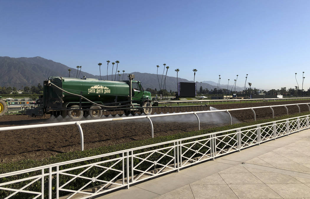 A truck waters the track at Santa Anita Park in Arcadia, Calif., Wednesday, Oct. 30, 3019. A tr ...
