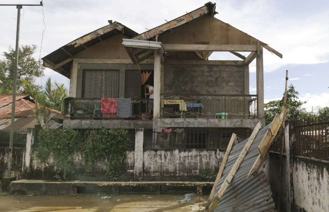 A resident checks his home damaged by Typhoon Phanfone in Ormoc city, central Philippines on Th ...