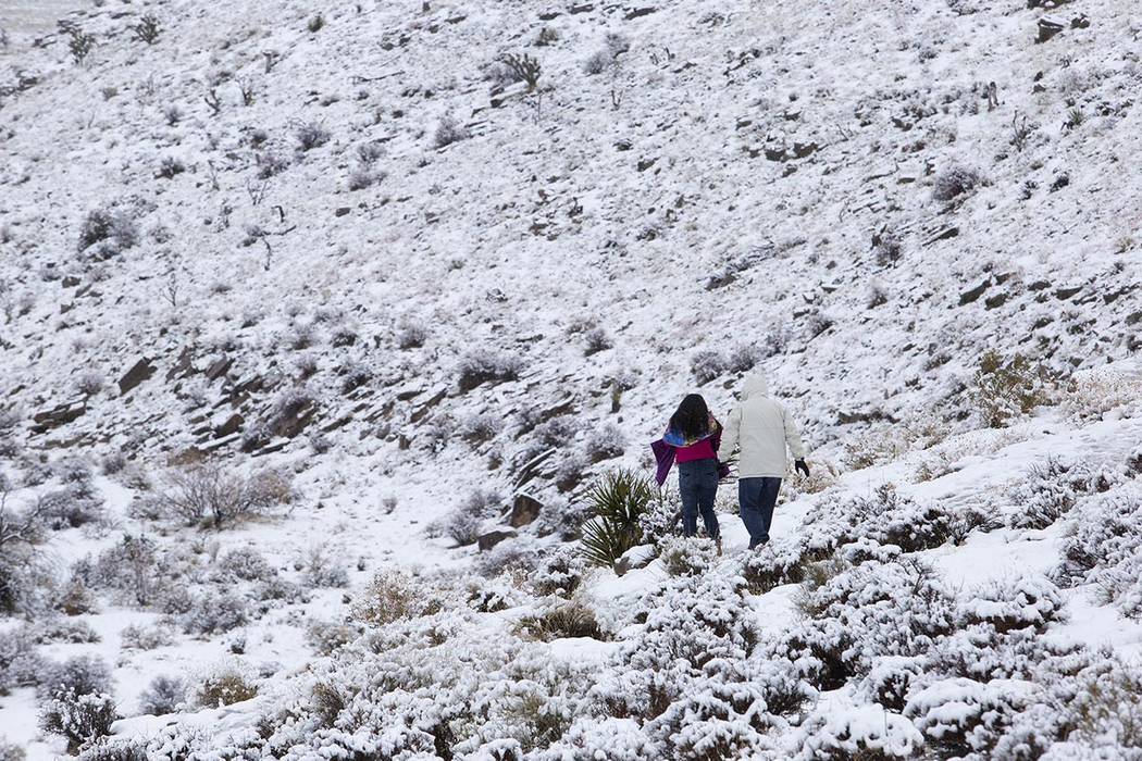 People walk through the snow at Red Rock Canyon Overlook on Thursday, Dec. 26, 2019, in Las Veg ...