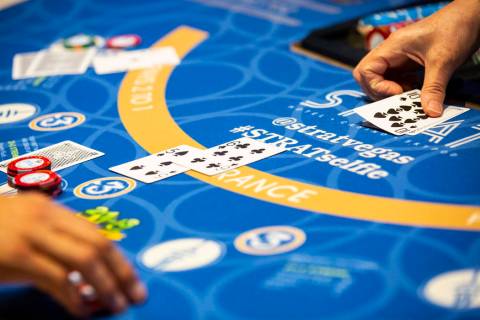 Blackjack dealer Amal Almisber, right, works the table at The Strat in Las Vegas on Wednesday, ...