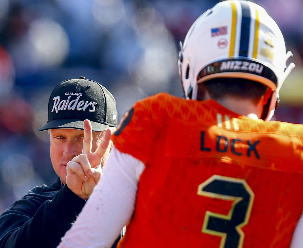 North head coach Jon Gruden of the Oakland Raiders talks with North quarterback Drew Lock of Mi ...