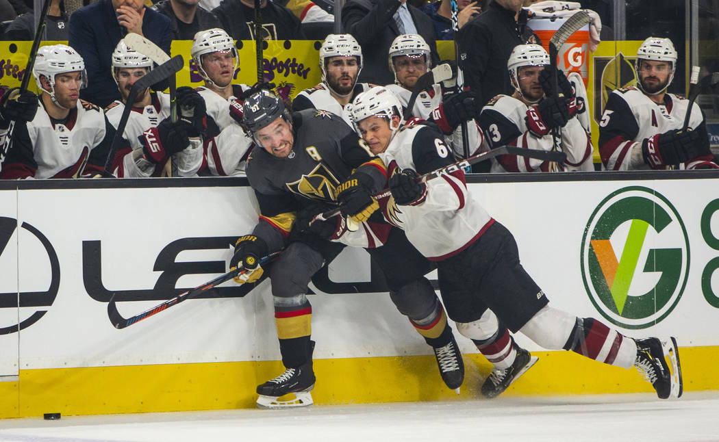 Vegas Golden Knights right wing Mark Stone (61, left) chases a puck as Arizona Coyotes defensem ...