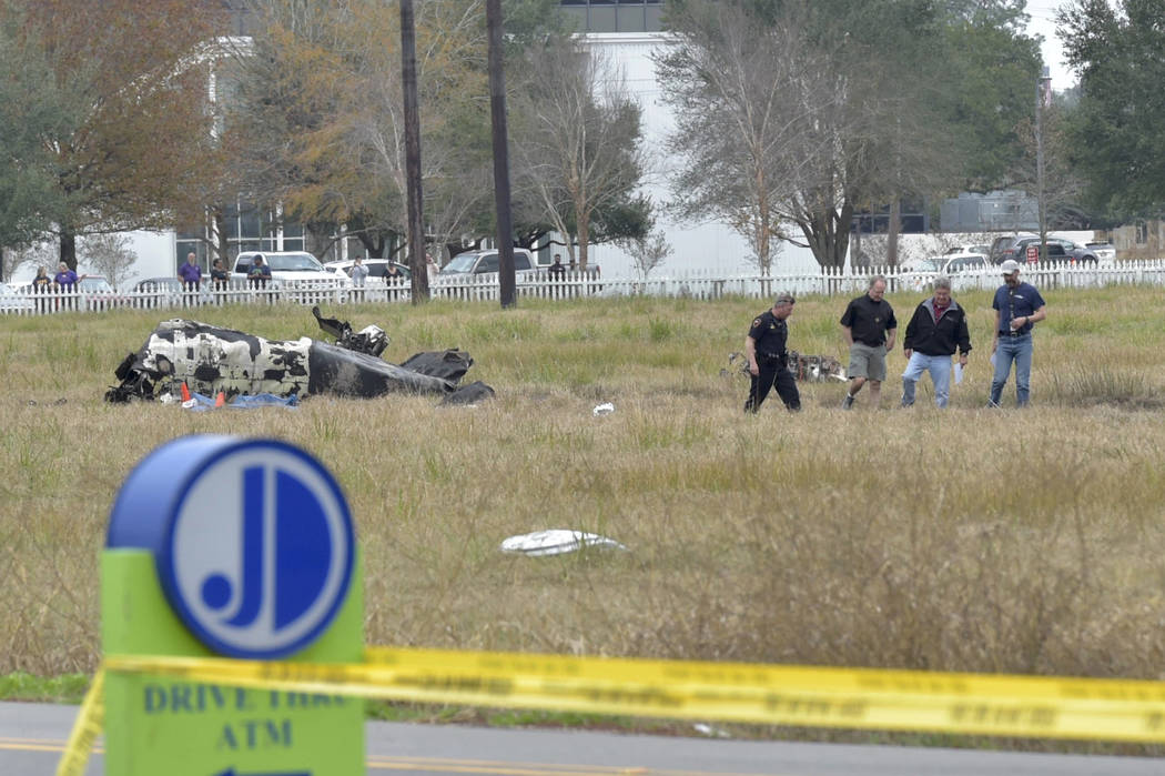 Investigators look over the site of a plane crash near Feu Follet Road and Verot School Road in ...