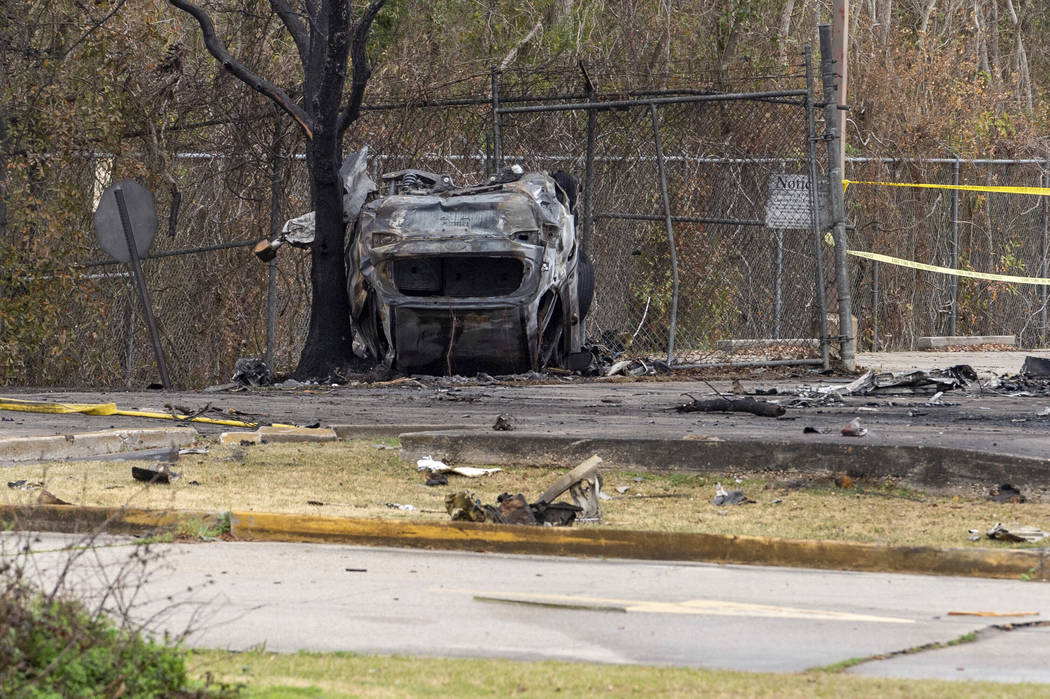 A view of a damaged vehicle near the site of a plane crash after a small plane crashed into the ...