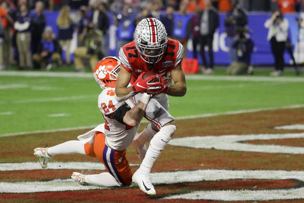 Ohio State wide receiver Chris Olave catches a touchdown pass in front of Clemson safety Nolan ...