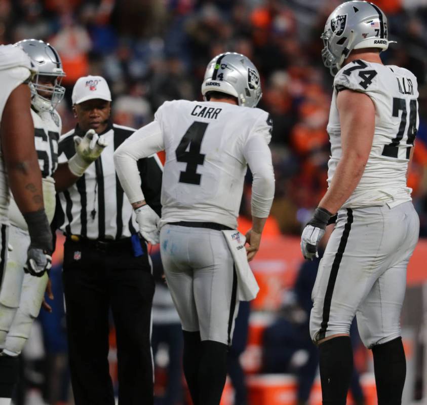 Oakland Raiders quarterback Derek Carr (4) gets up limping after being sacked by Denver Broncos ...