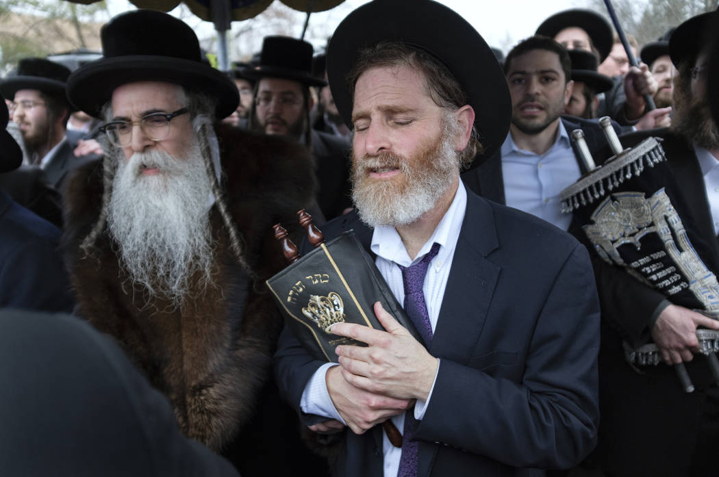 Community members, including Rabbi Chaim Rottenberg, left, celebrate the arrival of a new Torah ...
