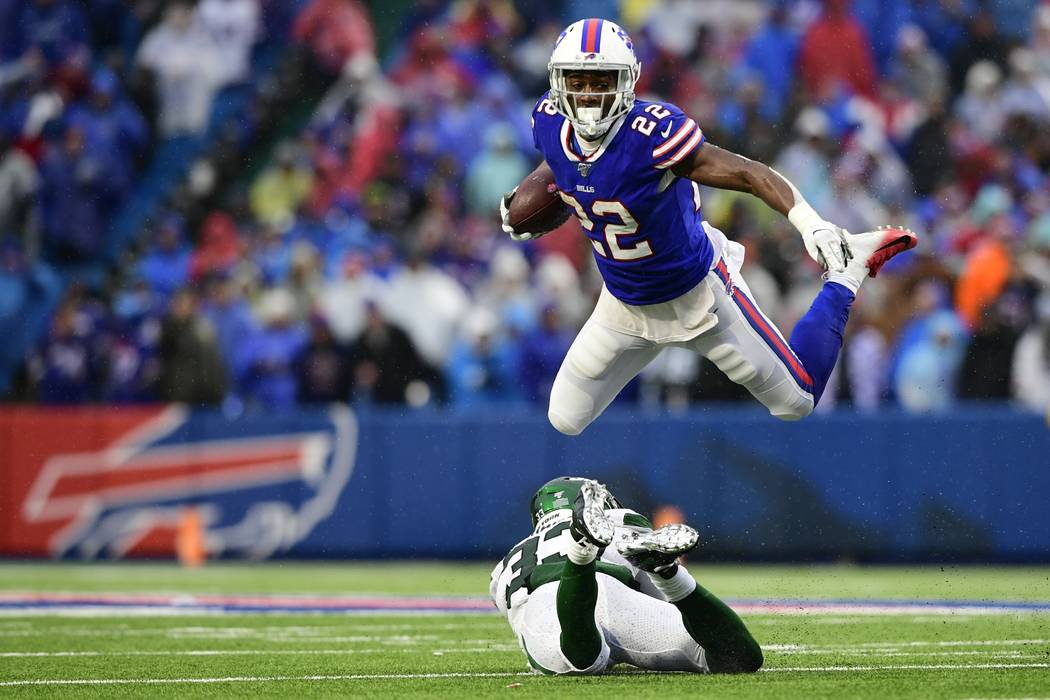 Buffalo Bills running back T.J. Yeldon (22) hurdles New York Jets strong safety Jamal Adams, bo ...