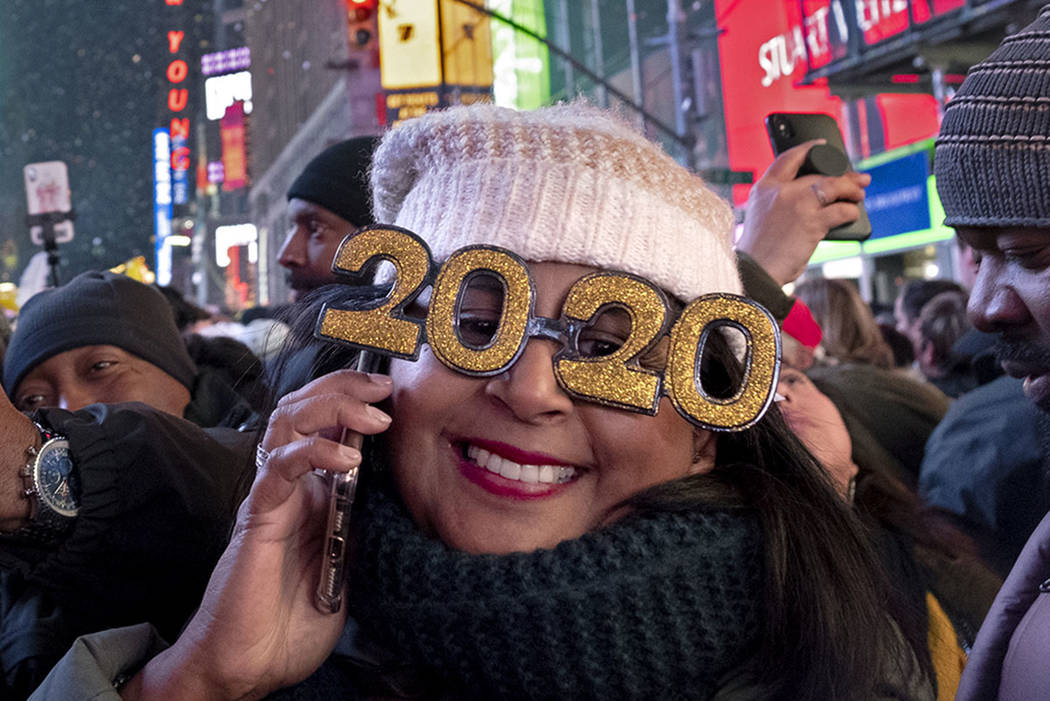 People celebrate the New Year on Times Square in New York, Wednesday, Jan. 1, 2020, (AP Photo/C ...