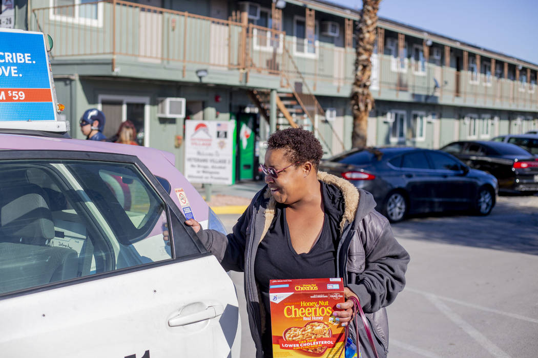 Alpine Motel tenant Tia Dotson gets into a complimentary taxi after a care package giveaway at ...