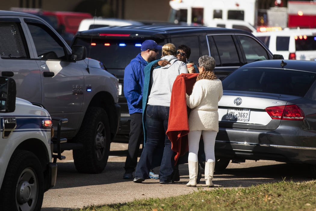 Residents embrace near police and fire cars that surround the scene of a shooting at West Freew ...