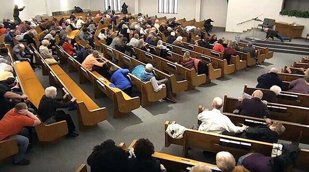 In this still frame from livestreamed video provided by law enforcement, churchgoers take cover ...