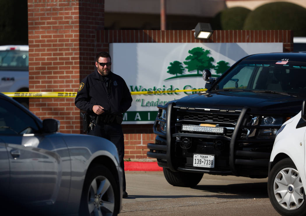 An officer stands near the scene after a church shooting at West Freeway Church of Christ on Su ...