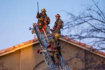 Firefighters with the Clark County Fire Department descend the roof of an apartment at the Glor ...