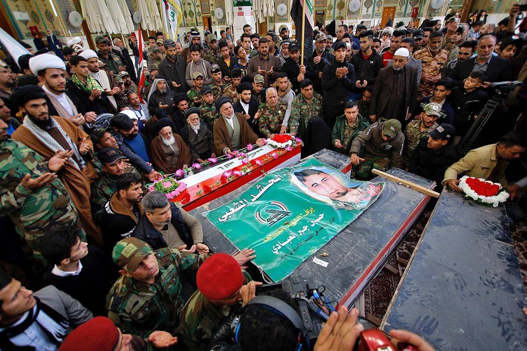 Mourners pray by coffins of Iran-backed Popular Mobilization fighters killed in a U.S. airstrik ...