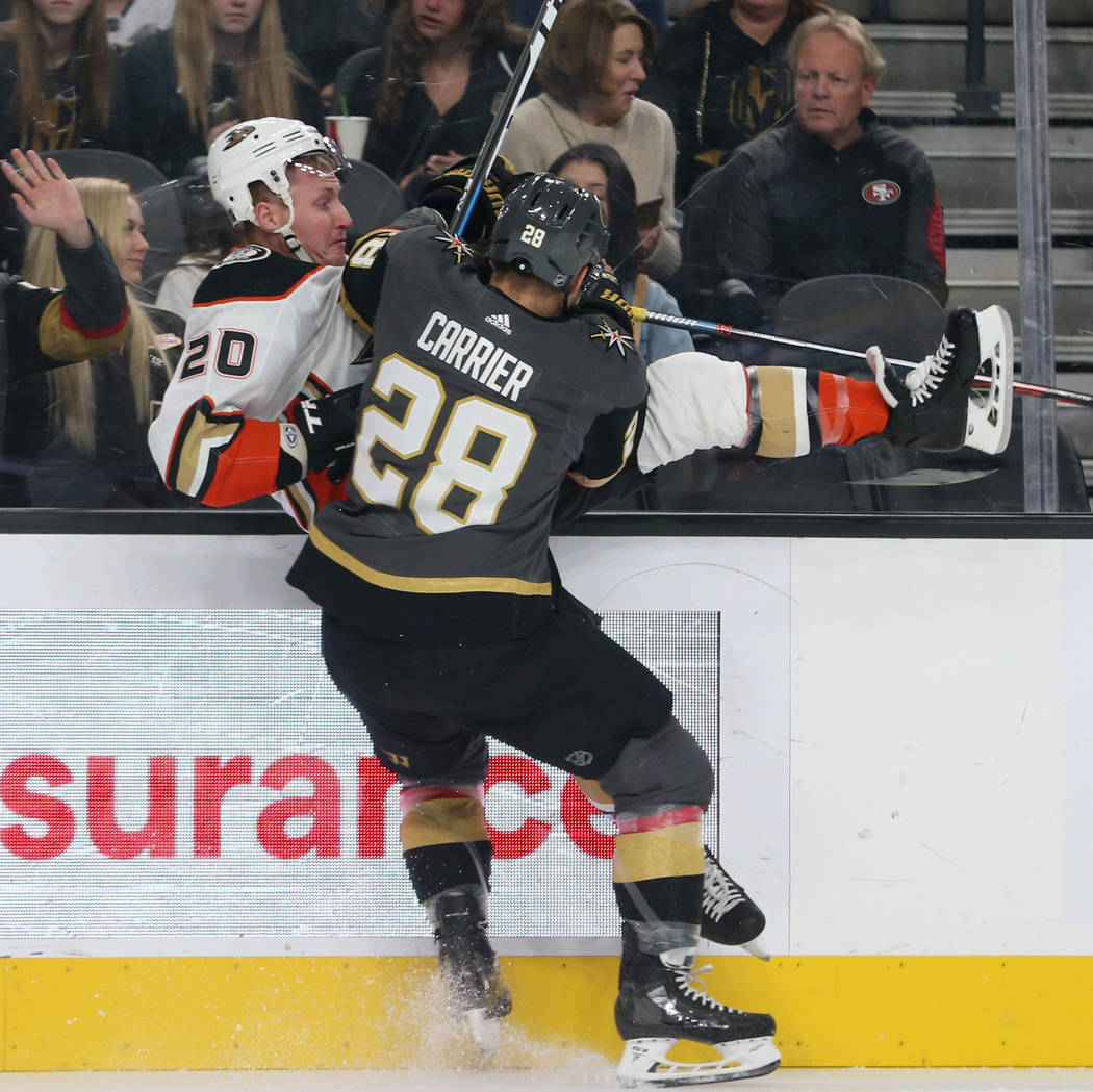 Vegas Golden Knights left wing William Carrier (28) gets a hit against Anaheim Ducks left wing ...