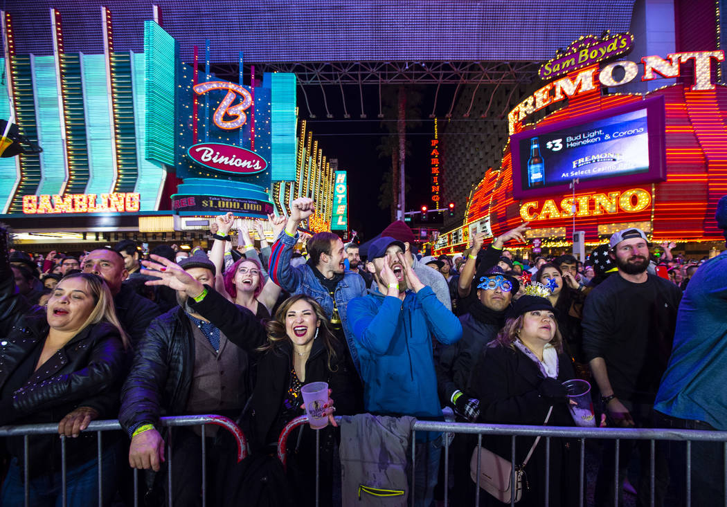 New Year's Eve revelers cheer by a stage at the Fremont Street Experience in downtown Las Vegas ...