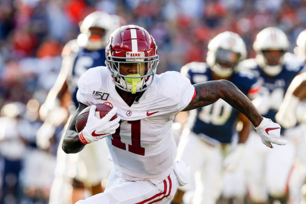 Alabama wide receiver Henry Ruggs III (11) caries the ball against Auburn during an NCAA colleg ...