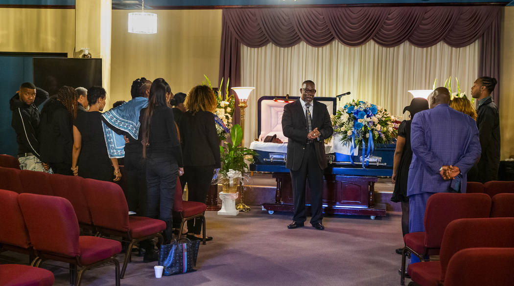 Bishop Tyrone L. Seals leads attendees in prayer for Don Bennett, a maintenance man and hero of ...