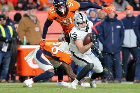 Oakland Raiders wide receiver Hunter Renfrow (13) catches the football as Denver Broncos defens ...