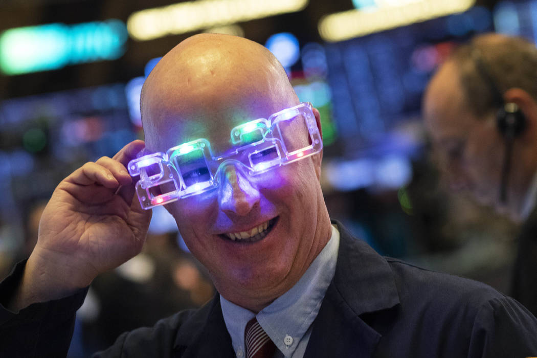 Stock trader John O'Hara tries on his New Year's 2020 party glasses at New York Stock Exchange, ...