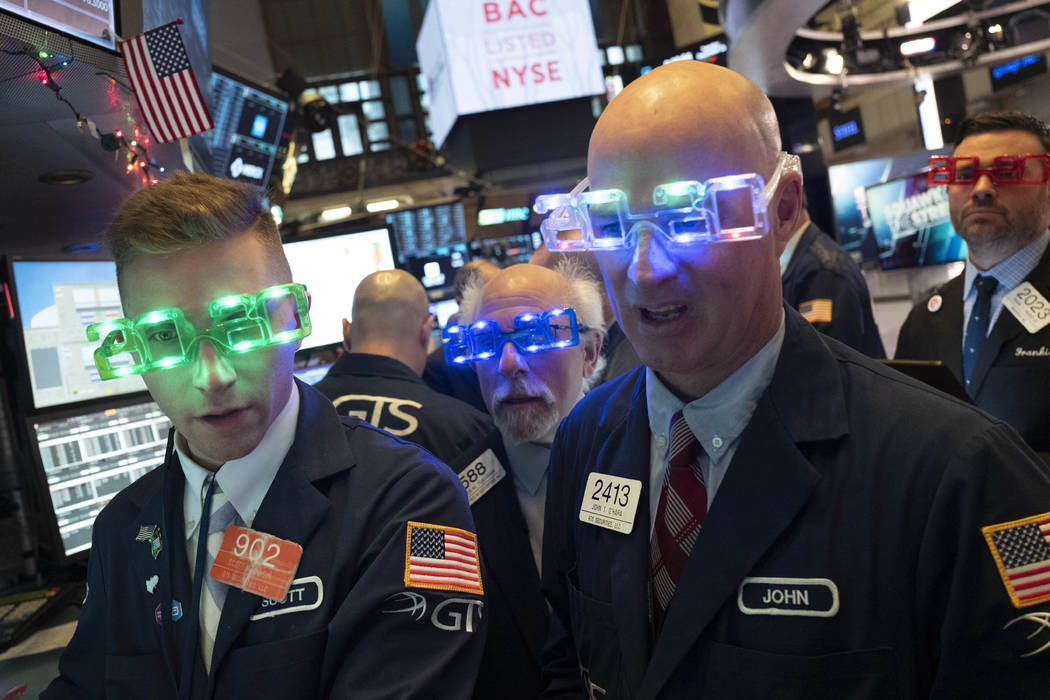 Stock traders wear New Year's 2020 party glasses at New York Stock Exchange, Tuesday, Dec. 31, ...