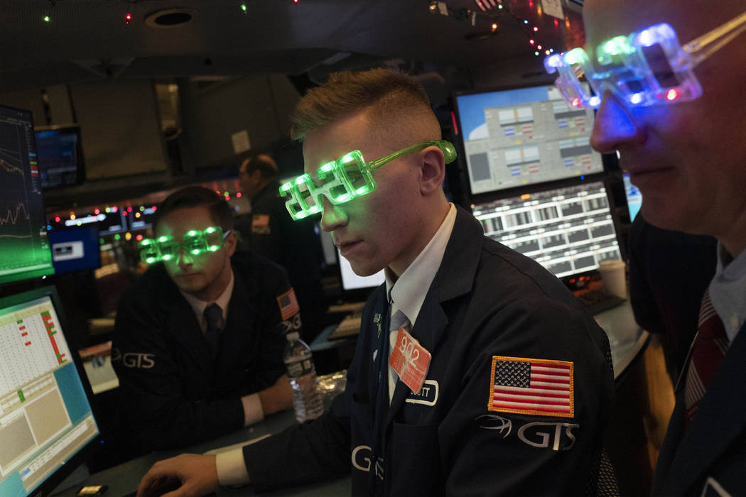 Stock traders wear New Year's 2020 party glasses at New York Stock Exchange, Tuesday, Dec. 31, ...