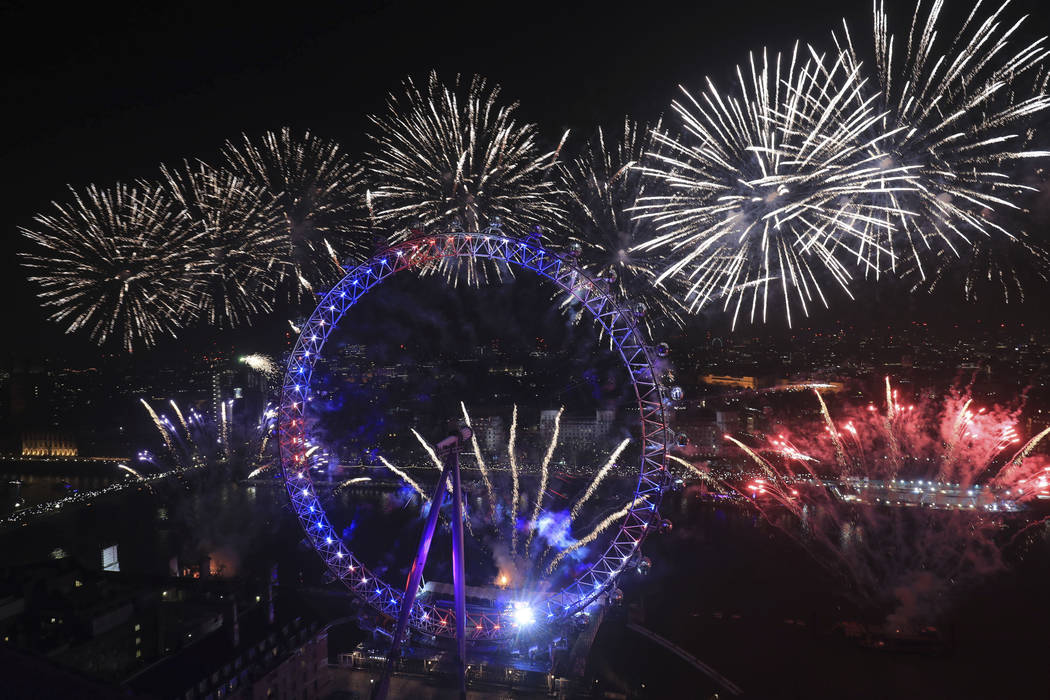 Fireworks explode over the London Eye Ferris wheel by the River Thames in London, to mark the s ...