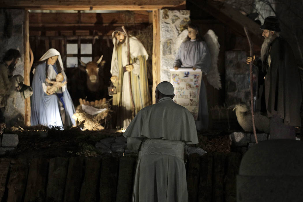Pope Francis stops by the Nativity exposed in St. Peter's square after presiding over vespers o ...