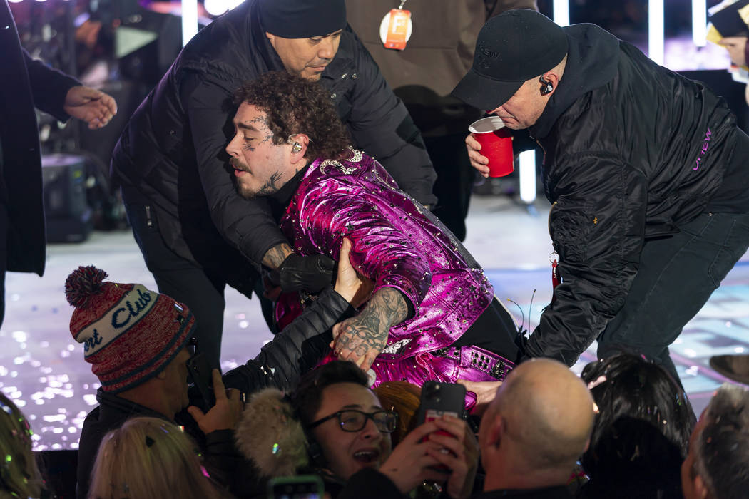 Post Malone falls off the stage at the Times Square New Year's Eve celebration on Tuesday, Dec. ...