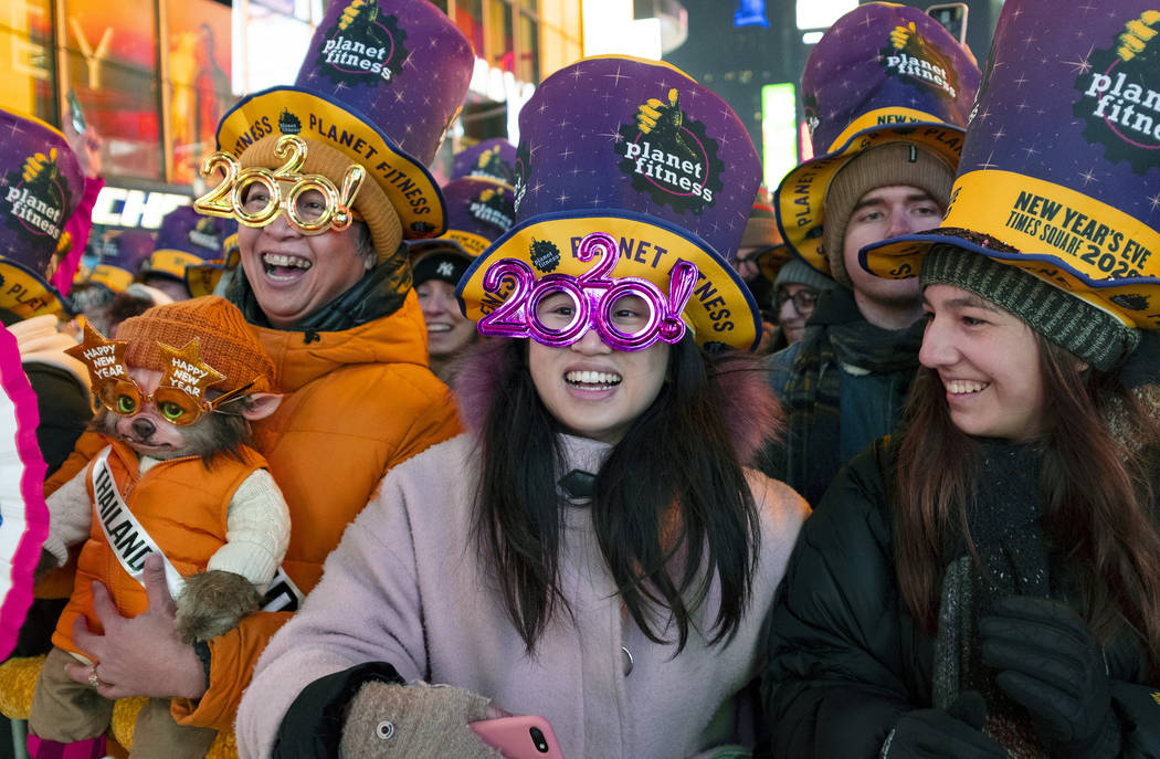 Revelers watch musical entertainment on Times Square in New York, Tuesday, Dec. 31, 2019, as pe ...