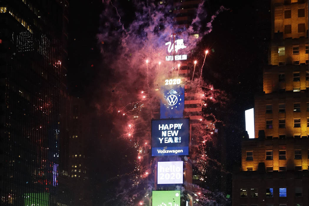 Confetti drops over the crowd as the clock strikes midnight during the New Year's celebration a ...