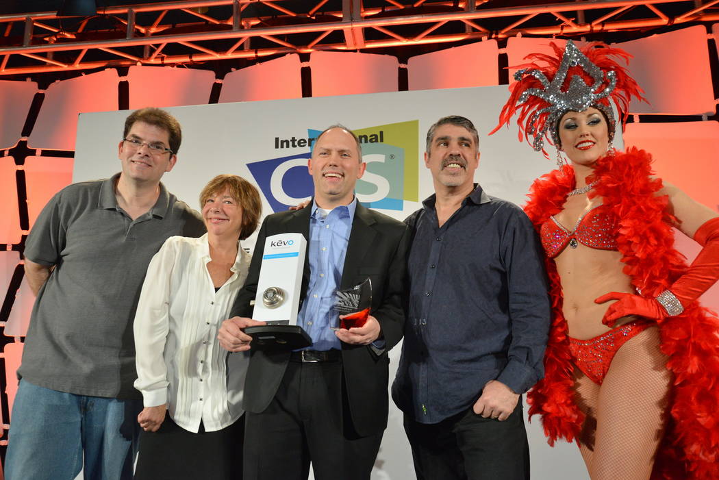 Last Gadget Standing winners, and a showgirl, display the Kevo Kwikset keyless smart lock, whic ...