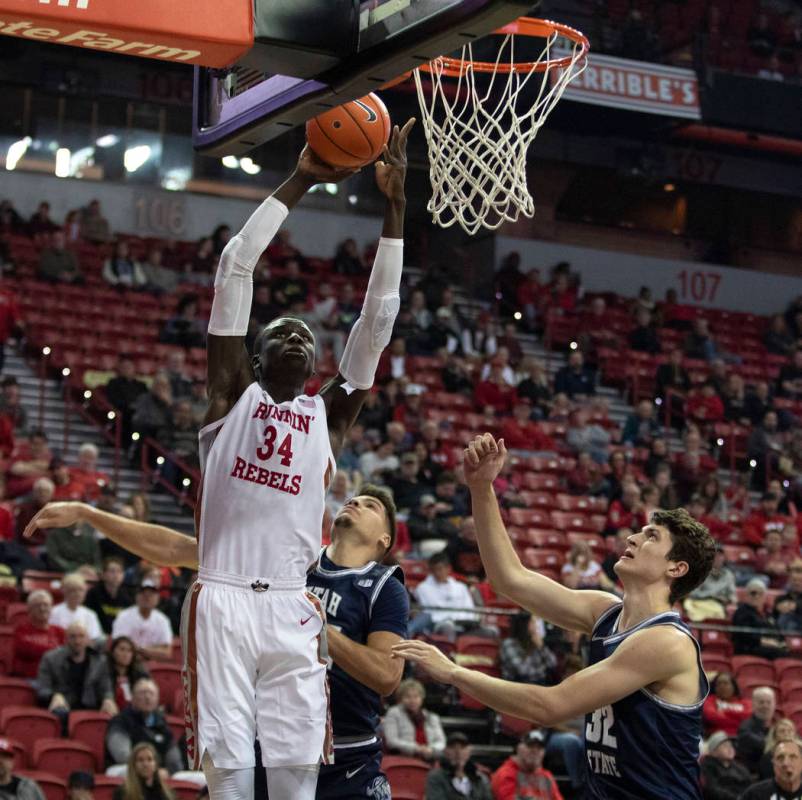 UNLV's forward Mbacke Diong shoots a point as Utah State's guard Diogo Brito (24) and center Tr ...