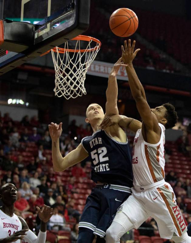 UNLV's forward Nick Blair (20) shoots a point as Utah State's center Kuba Karwowski (52) jumps ...