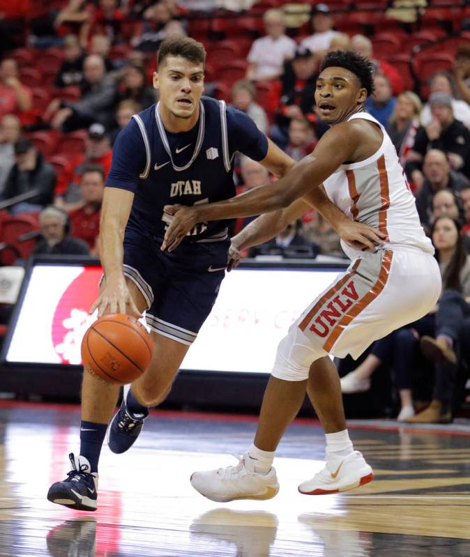 Utah State's Diogo Brito drives around UNLV's Bryce Hamilton during the first half of an NCAA c ...