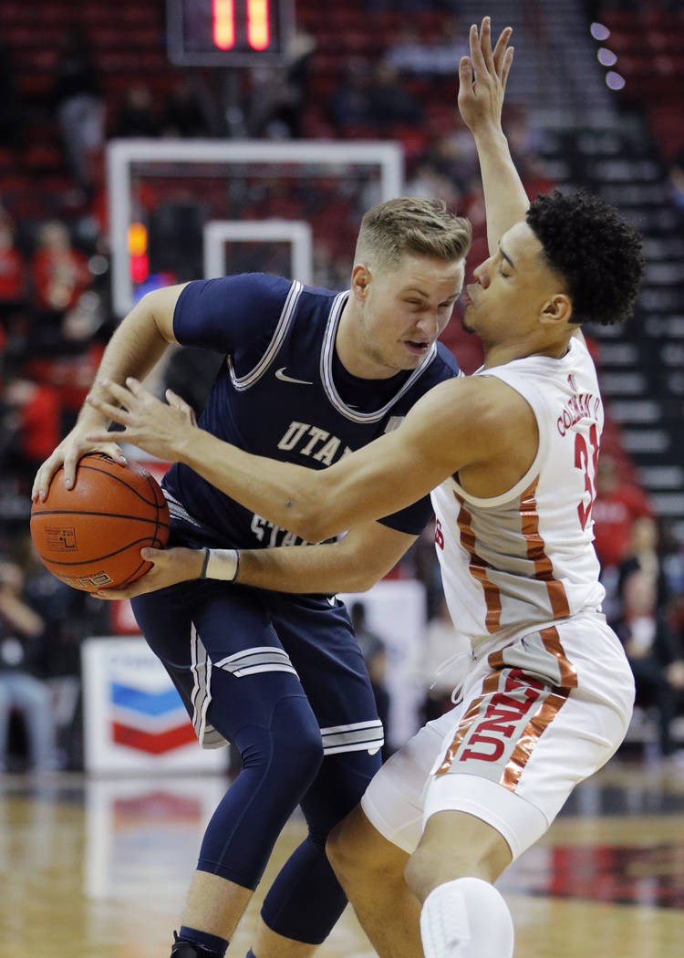 Utah State's Sam Merrill drives against UNLV's Marvin Coleman (31) during the first half of an ...