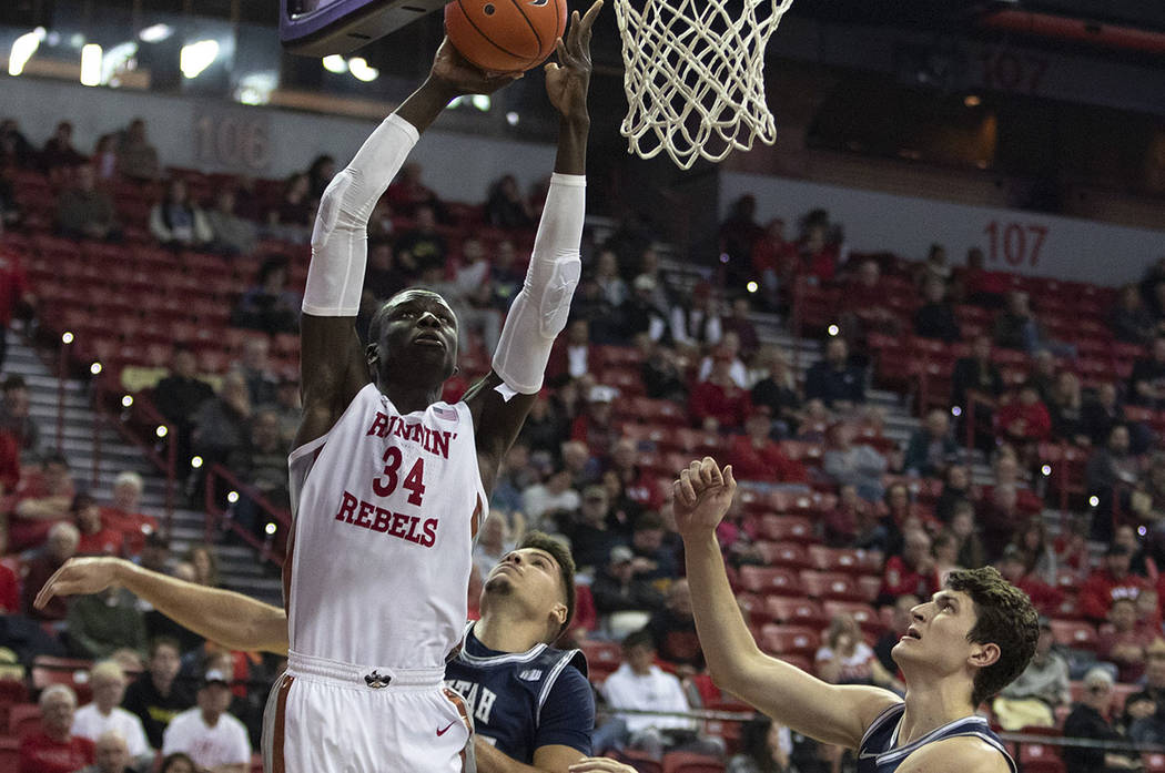 UNLV's forward Mbacke Diong shoots a point as Utah State's guard Diogo Brito (24) and center Tr ...