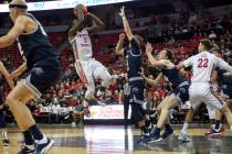 UNLV's guard Amauri Hardy (3) jumps to shoot a point as Utah State players reach to block him d ...