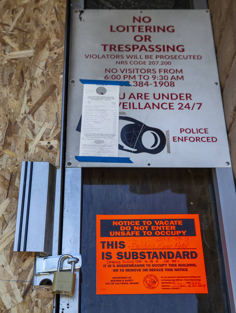 The front door is padlocked and marked with a dangerous building sign issued by the City of Las ...