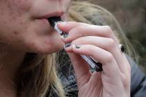 In this April 11, 2018, file photo, a 15-year-old high school student uses a vaping device near ...