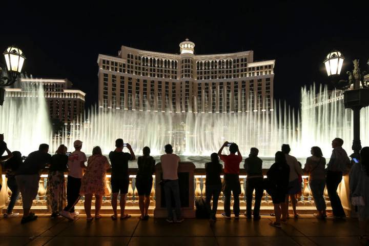 People watch the water fountain show outside the Bellagio hotel and casino on the Strip in Las ...