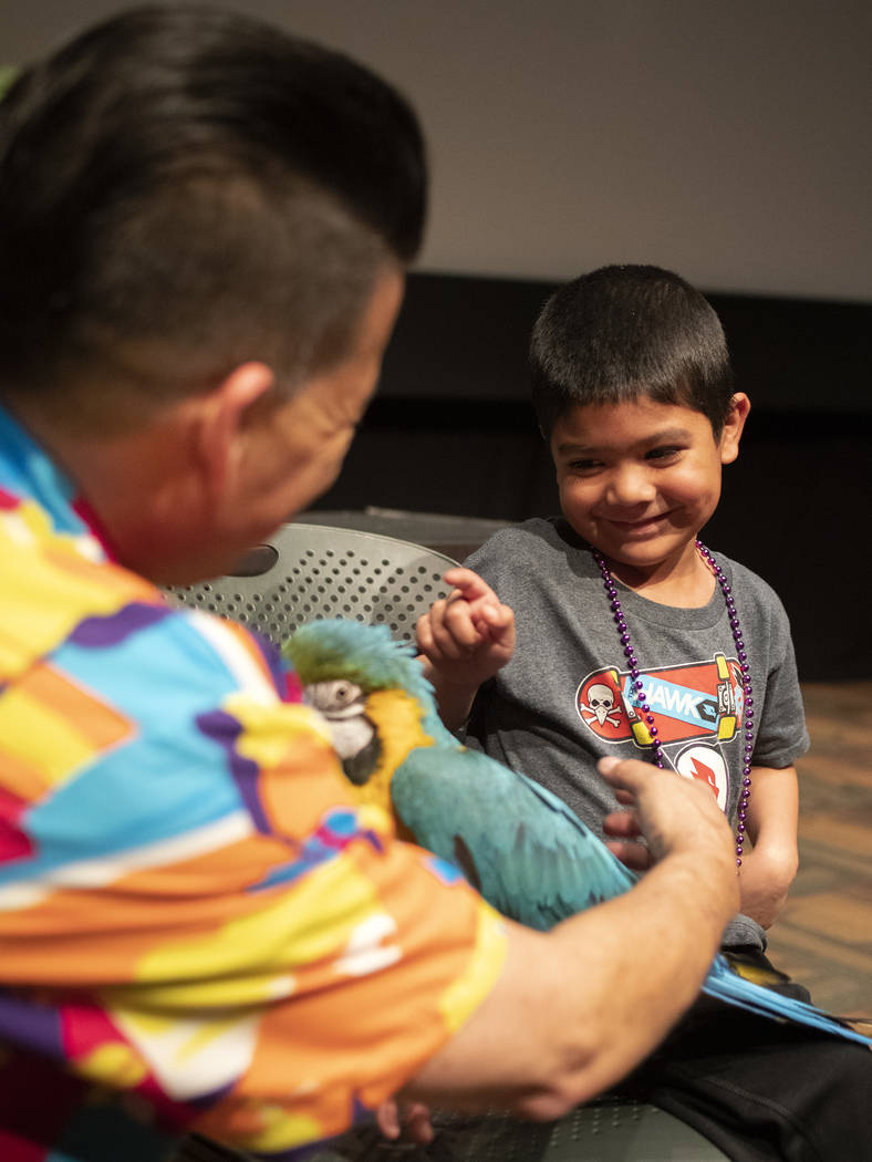 Steven Hafner, 6, of Las Vegas, is shy as Clint Carvalho shows him how to pet a parrot after Ca ...
