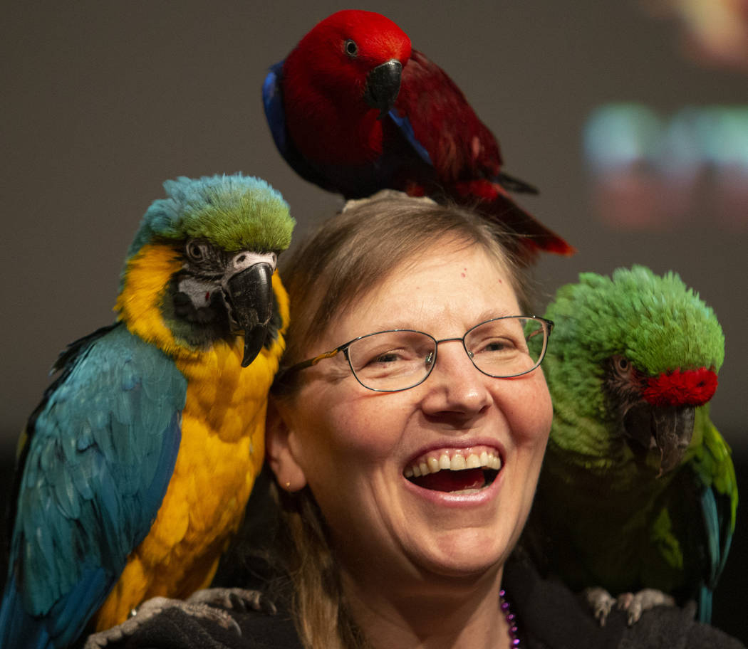 Lorien Smyer of California poses for a photo with parrots after Clint Carvalho's Extreme Parrot ...