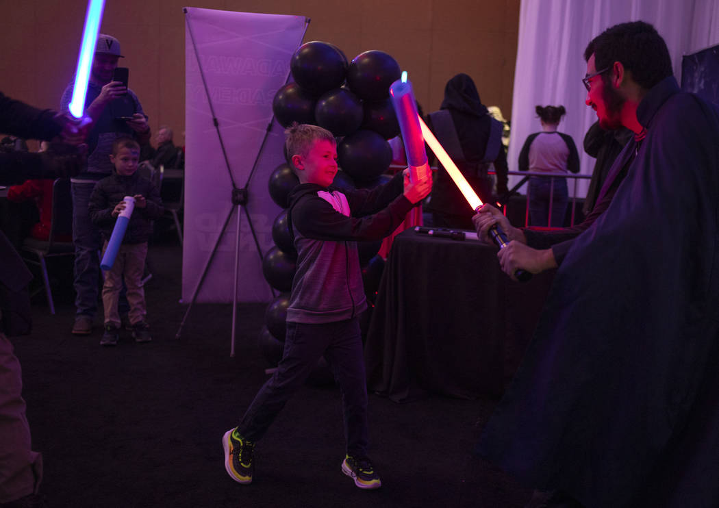 Tanner Ash, 8, of Las Vegas, duels with members of the Society of Light Saber Duelists UNLV at ...