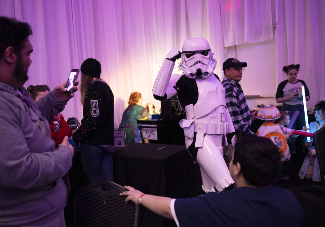 A Storm Trooper does the "hype dance" for Sammy Marks, left, and Rocky Marks, right, ...