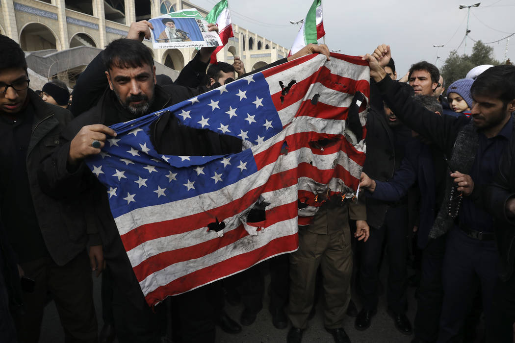 Protesters burn a U.S. flag during a demonstration over the U.S. airstrike in Iraq that killed ...