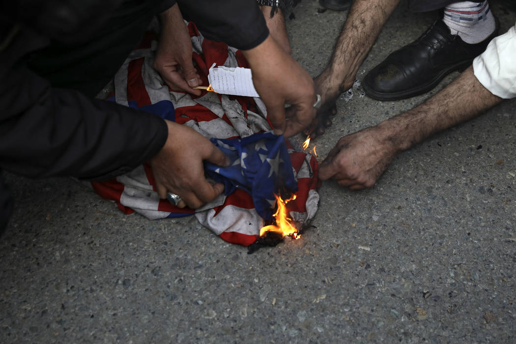 Protesters burn a U.S. flag during a demonstration over the U.S. airstrike in Iraq that killed ...