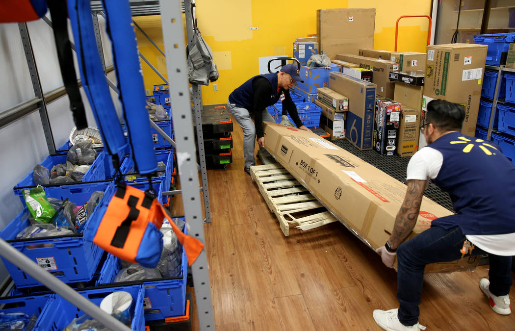Personal shopper Nick Deleon, left, and department manager Richard Ramirez prepare a customer's ...