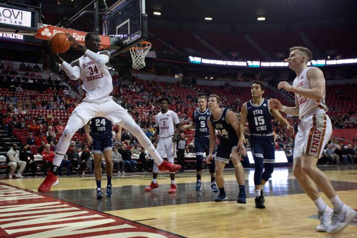 UNLV's forward Mbacke Diong (34) grabs the ball on defense as Utah State players look on during ...